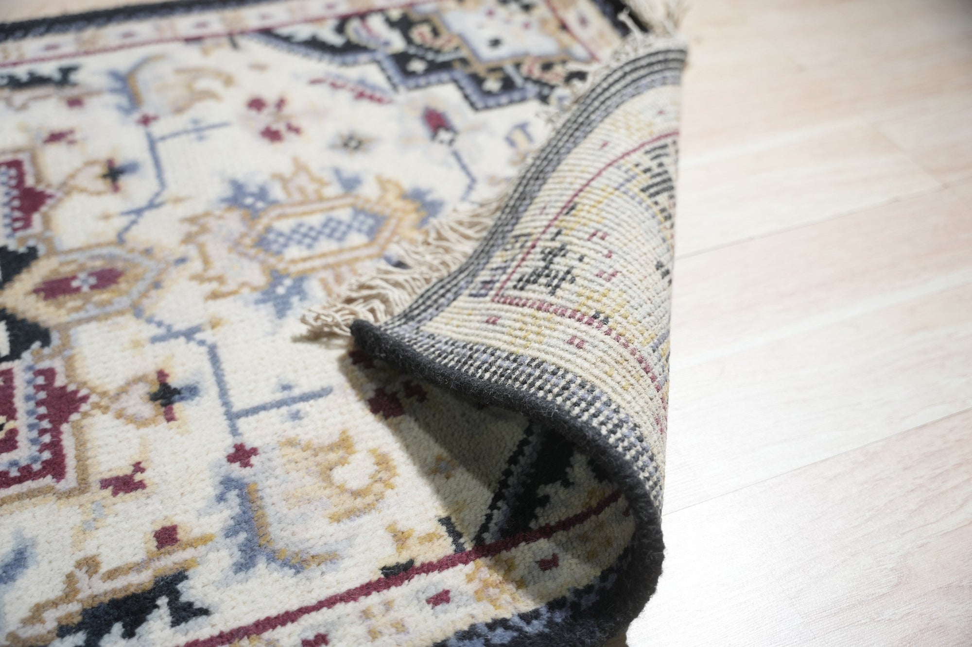 Luxurious Traditional Beige Hand Knotted Wool Rug, a beige wool rug featuring an ornate traditional design, draped elegantly to display its texture and pattern.
