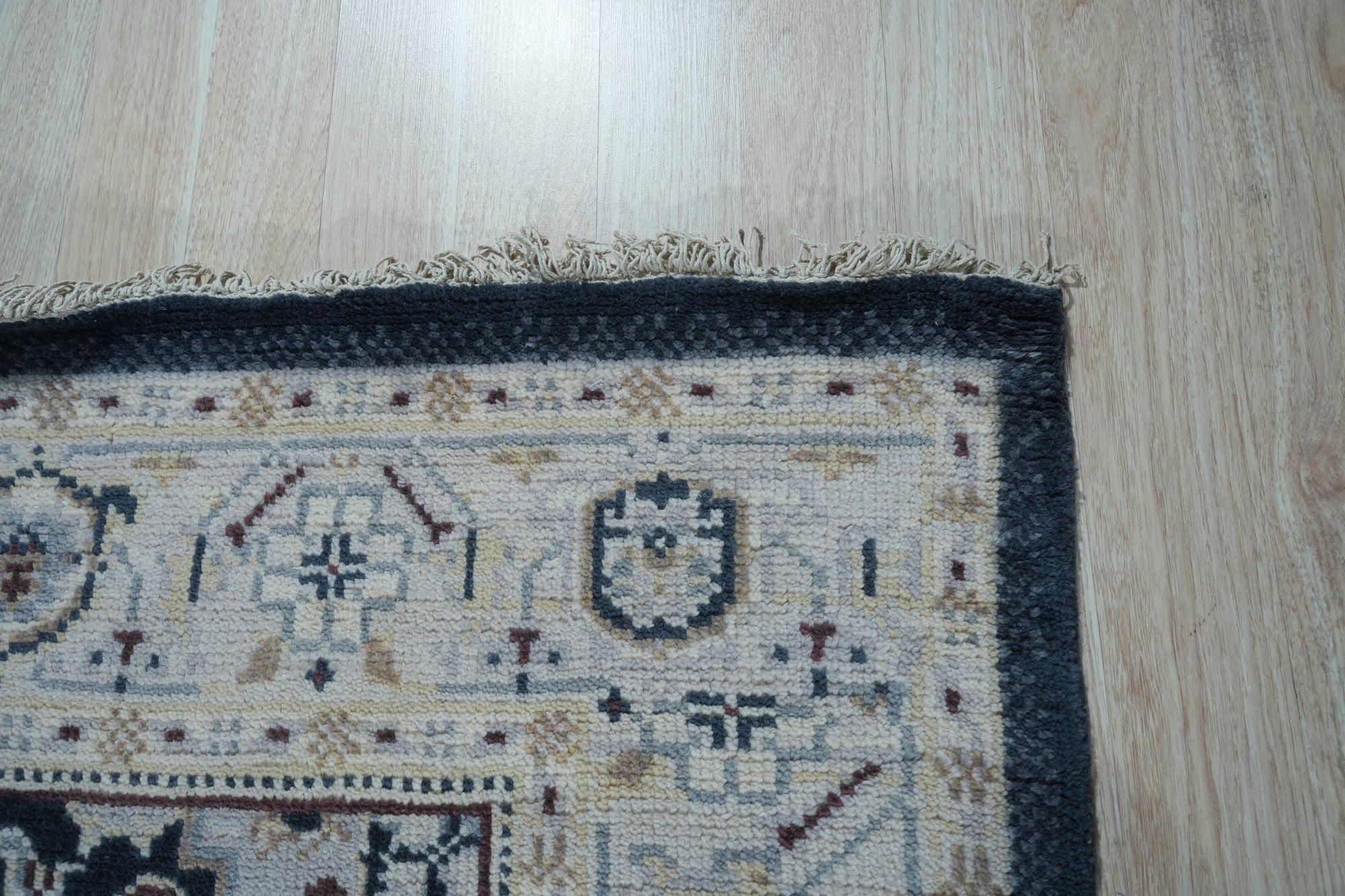 Luxurious Traditional Beige Hand Knotted Wool Rug, seen in a warm, inviting setting. Beige wool rug with intricate, traditional patterns. Hand-knotted construction apparent in the detailed weave.