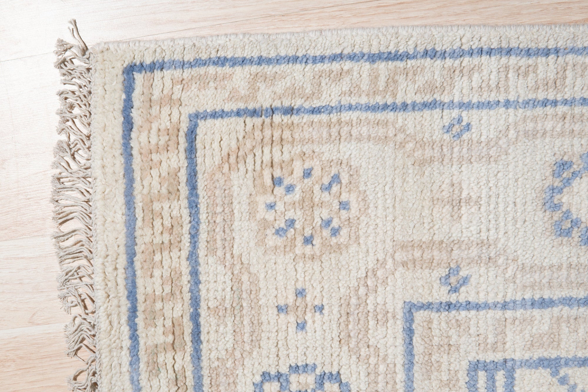 Ava Sophie Beige Hand Knotted Wool Rug, a warm, inviting layer adding subtle texture to a bright living space, showcasing its intricate hand-knotted construction and soft beige tones under natural light.