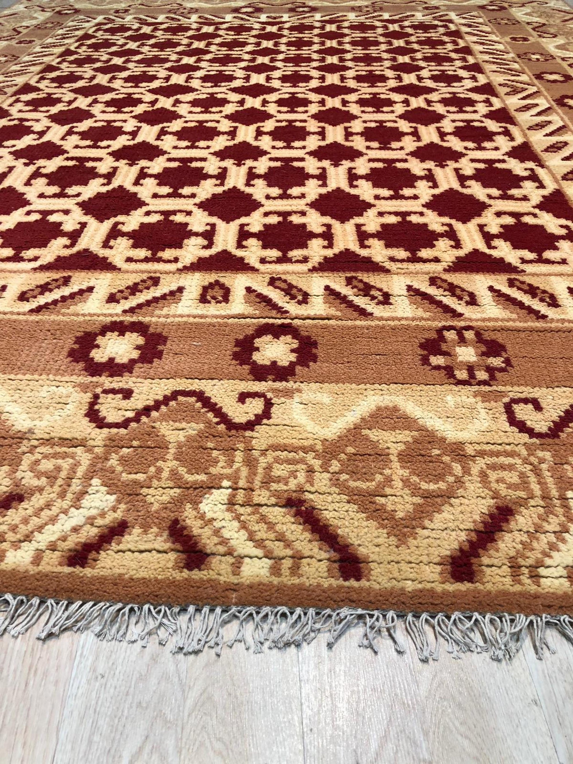Chloe Trara Red Hand Knotted Wool Rug, a vibrant red wool rug with intricate, hand-knotted detailing, filling a bright, airy living space.