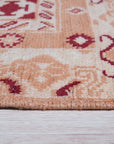 Chloe Trara Red Hand Knotted Wool Rug, showcasing intricate patterns woven in rich red tones, lies gracefully on a light hardwood floor, its luxurious texture inviting touch.