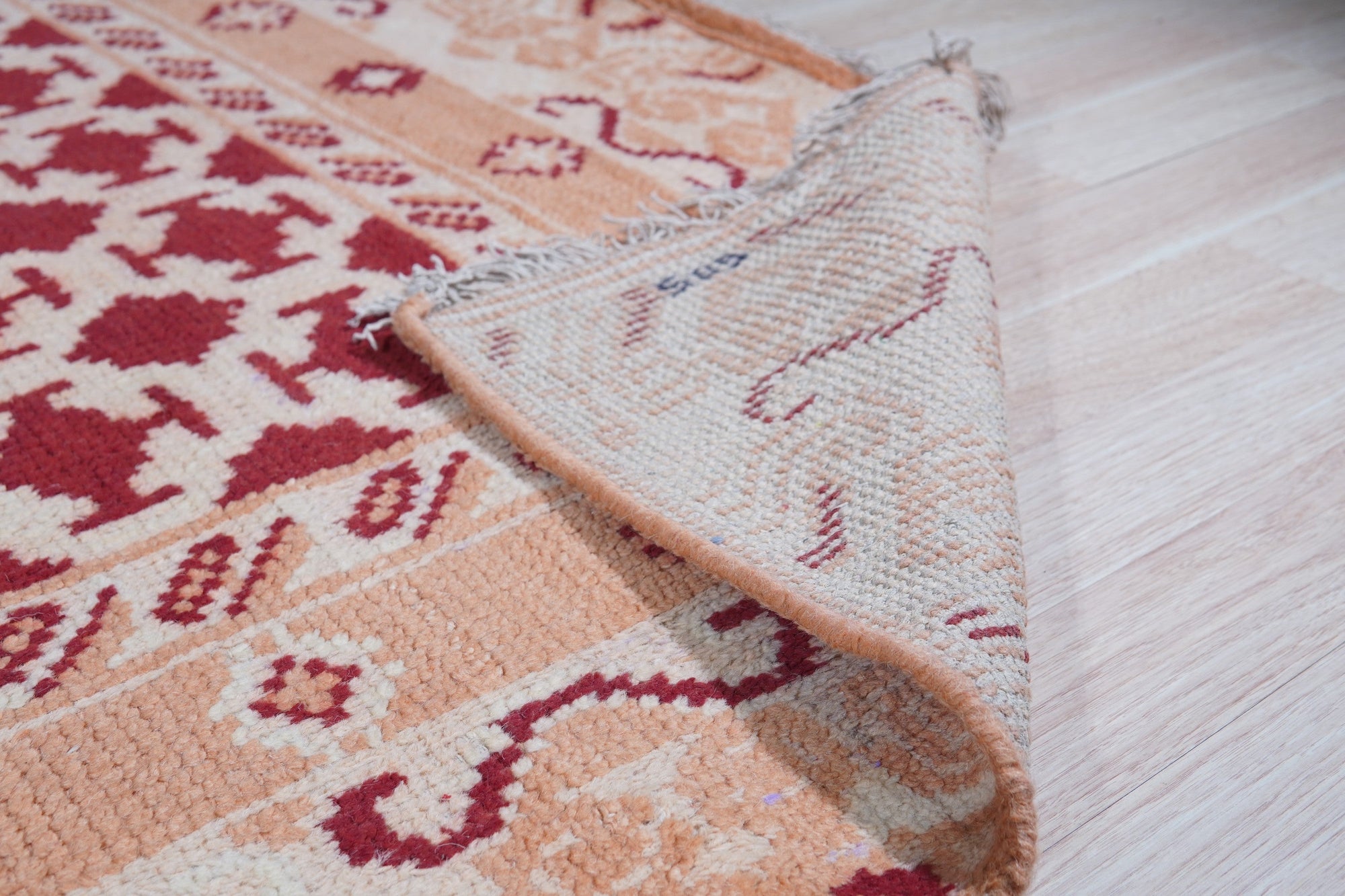 Chloe Trara Red Hand Knotted Wool Rug, bursts with vibrant red hues and intricate hand-knotted detail, adding warmth and texture to a bright, modern living space.