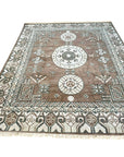 Trendy Traditional Brown Hand Knotted Wool Rug, warm brown wool pile displaying intricate traditional patterns, filling the floor space in a bright, welcoming room.