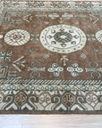 Trendy Traditional Brown Hand Knotted Wool Rug, a brown wool rug with a traditional design, seen in a bright, neutral room setting showcasing its pattern and texture.
