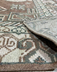 Trendy Traditional Brown Hand Knotted Wool Rug, showcasing a complex, traditional pattern in warm browns and creams. The hand-knotted construction is visible, suggesting high quality and durability. Seen in a styled setting, hinting at its ability to complement various decors.