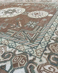 Trendy Traditional Brown Hand Knotted Wool Rug, showcasing warm brown tones and intricate traditional patterns, displayed in a brightly lit room with modern furniture.