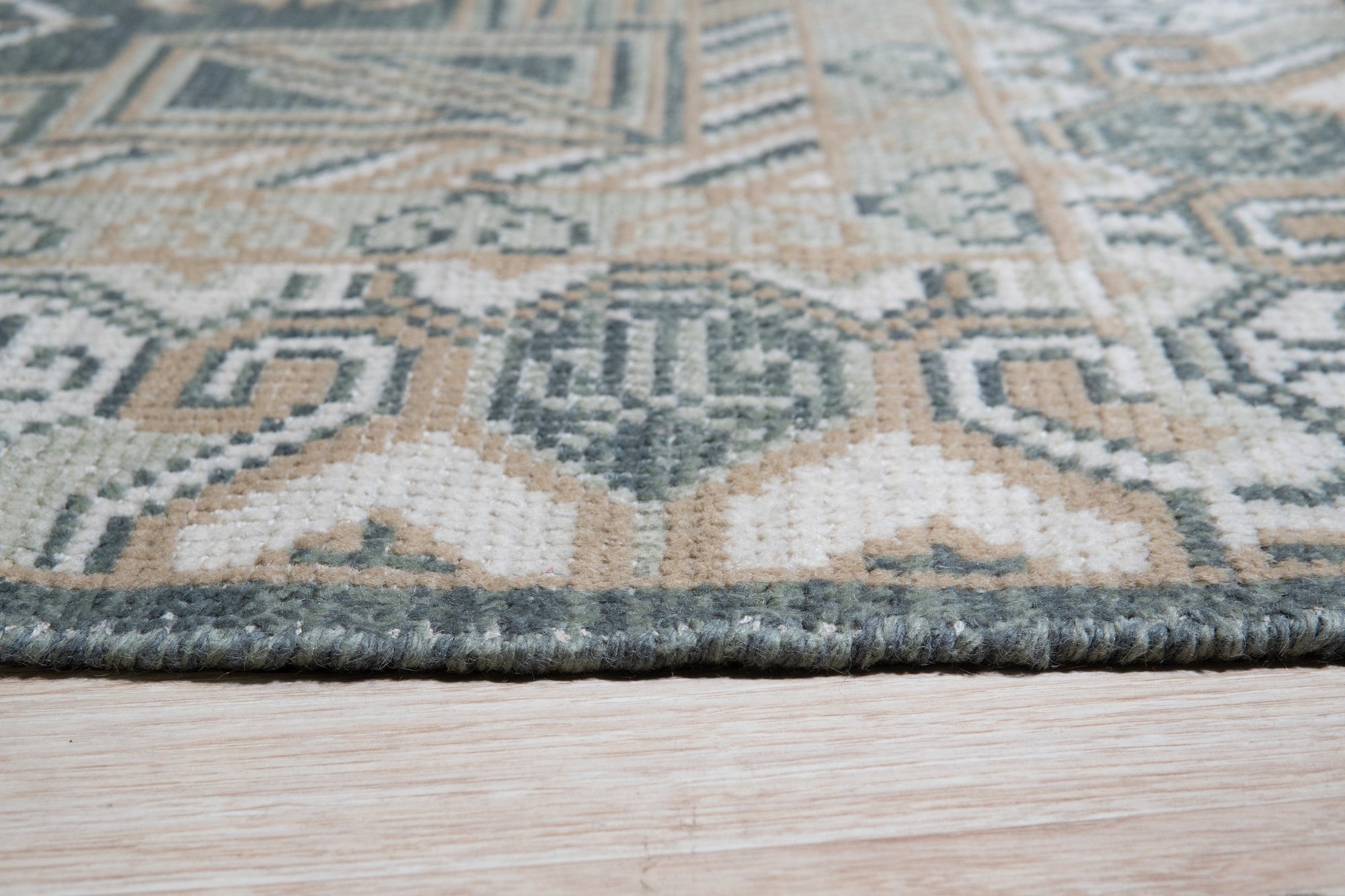 Rhea Traditional Green Hand Knotted Wool Rug, with a classic, ornate pattern in shades of green, ivory, and brown, displayed in a bright, modern living room setting.