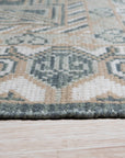 Rhea Traditional Green Hand Knotted Wool Rug, with a classic, ornate pattern in shades of green, ivory, and brown, displayed in a bright, modern living room setting.