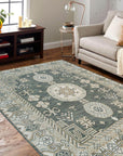 Rhea Traditional Green Hand Knotted Wool Rug, a rich green hand-knotted wool rug with intricate traditional patterns, displayed on a light hardwood floor, subtly textured and inviting.