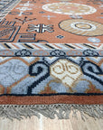 Jade Traditional Rust Hand Knotted Wool Rug displayed with warm, inviting lighting. Hand-knotted wool construction evident in the intricate pattern featuring rust hues and traditional motifs.