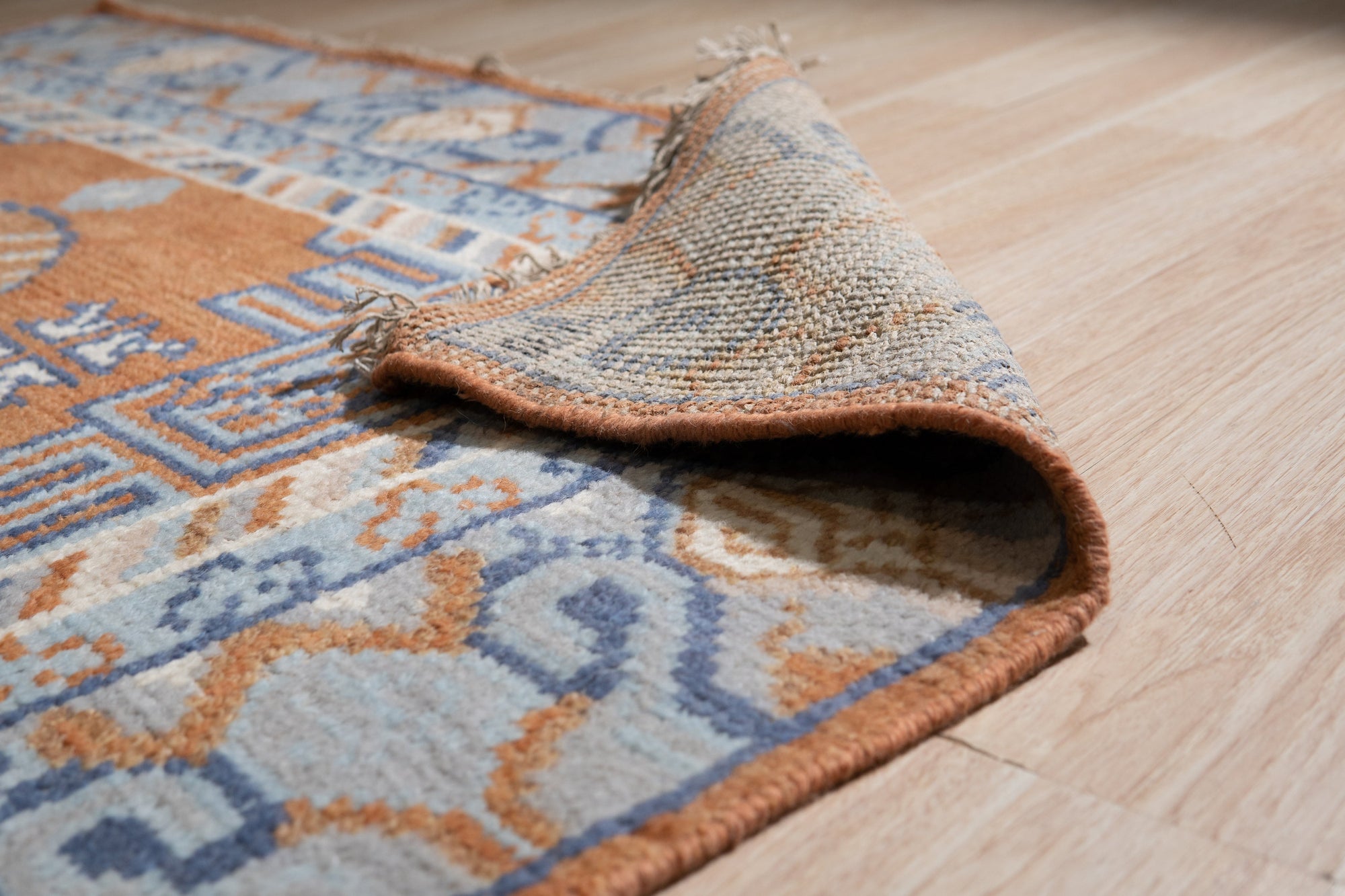 Jade Traditional Rust Hand Knotted Wool Rug, displaying intricate rust-toned patterns and hand-knotted construction in a well-lit interior setting.