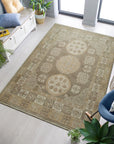 Classic Tessa Brown Hand Knotted Wool Rug, a warm brown wool rug with a subtle geometric pattern, partially visible beneath a light-colored sofa and wooden coffee table.