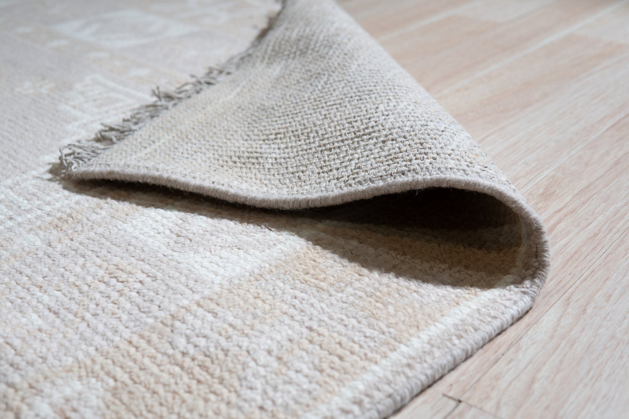 Classic Tessa Brown Hand Knotted Wool Rug, showcasing rich brown tones and intricate hand-knotted detailing, lays flat on a polished floor, inviting warmth and timeless elegance into a well-lit living space.
