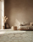 Classic Tessa Brown Hand Knotted Wool Rug, featuring a subtle geometric pattern in warm browns and creams, complements a modern living space with a light wood floor and minimalist decor.