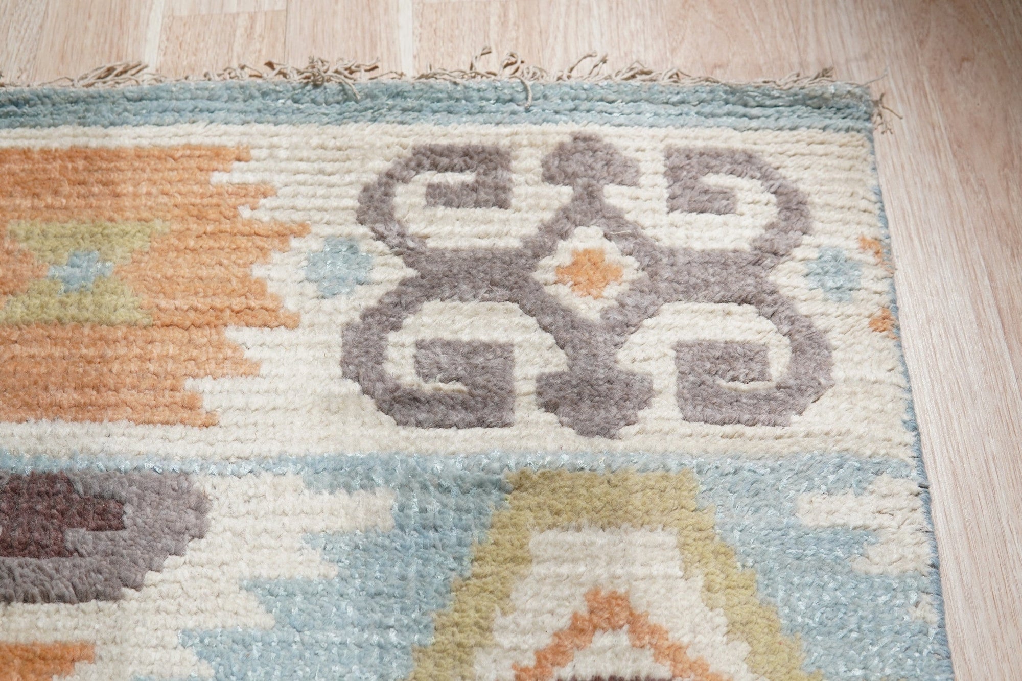 Freya Traditional Blue Hand Knotted Wool Rug, its intricate, time-honored patterns rendered in calming blues and creams, graces a warmly lit space.