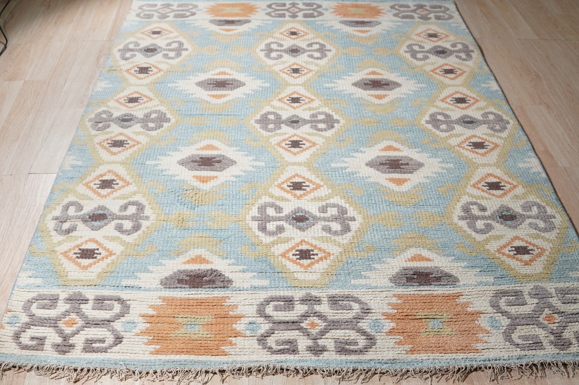 Freya Traditional Blue Hand Knotted Wool Rug, a blue wool rug with a traditional design, seen in a bright room setting with coordinating furniture, showcasing its intricate pattern and hand-knotted construction.