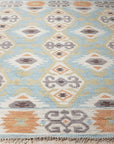 Freya Traditional Blue Hand Knotted Wool Rug, a blue wool rug with a traditional design, seen in a bright room setting with coordinating furniture, showcasing its intricate pattern and hand-knotted construction.