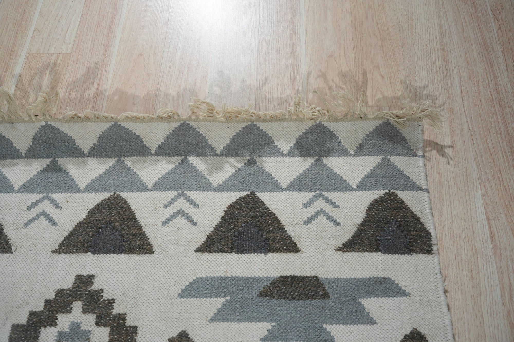 Chic Kilim Ivory Flatweave Rug, its intricate geometric patterns and subtle texture enhancing a bright, modern living space.