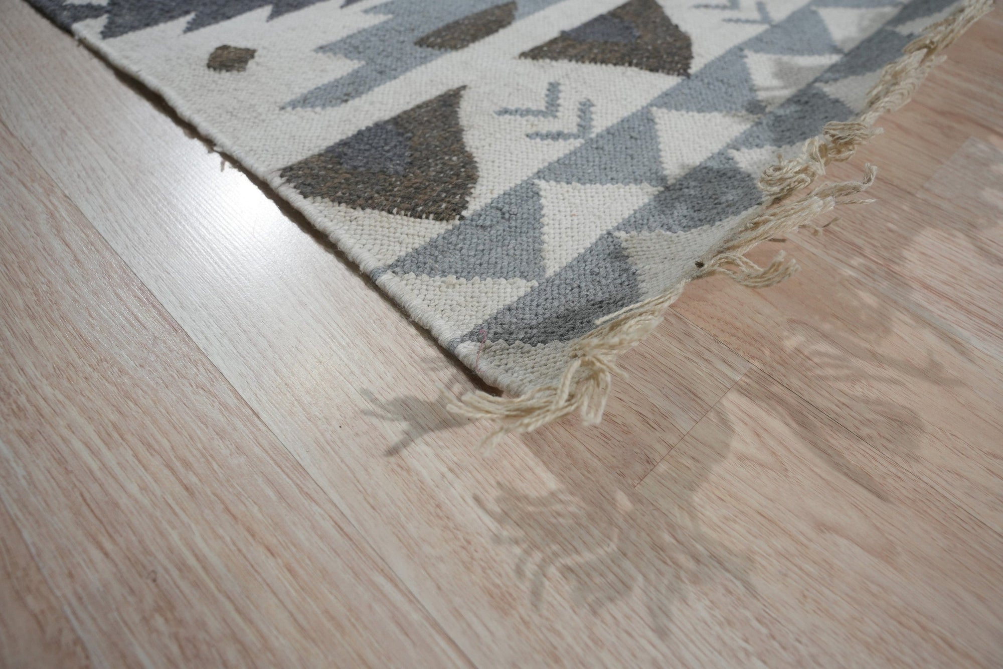 Chic Kilim Ivory Flatweave Rug, showcasing its geometric pattern in creamy ivory, laid in a bright living room setting.
