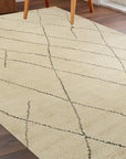 Jade Trellis Beige Hand Knotted Wool Rug, its delicate trellis pattern rendered in soft beige wool, lays nestled on hardwood flooring, showcasing its intricate hand-knotted construction and refined aesthetic.