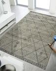 Captivating Moroccan Gray Hand Knotted Wool Rug, featuring a subtly patterned design, seen in a bright interior setting with contemporary furniture.
