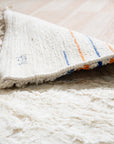 Delicate Moroccan Beige Hand Knotted Wool Rug, a beige wool rug with a Moroccan-inspired design, displayed in a room setting with natural light.