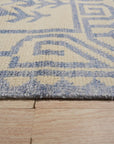 Louie Para Blue Hand Knotted Wool & Bamboo Silk Rug, showcasing a complex, abstract geometric pattern in varying shades of blue with shimmering bamboo silk highlights, resting on a light-colored floor.