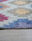Sumptuous Majestic Multicolor Hand Knotted Wool & Bamboo Silk Rug, its vibrant hues swirling in a captivating abstract design, laying elegantly on a polished wood floor.