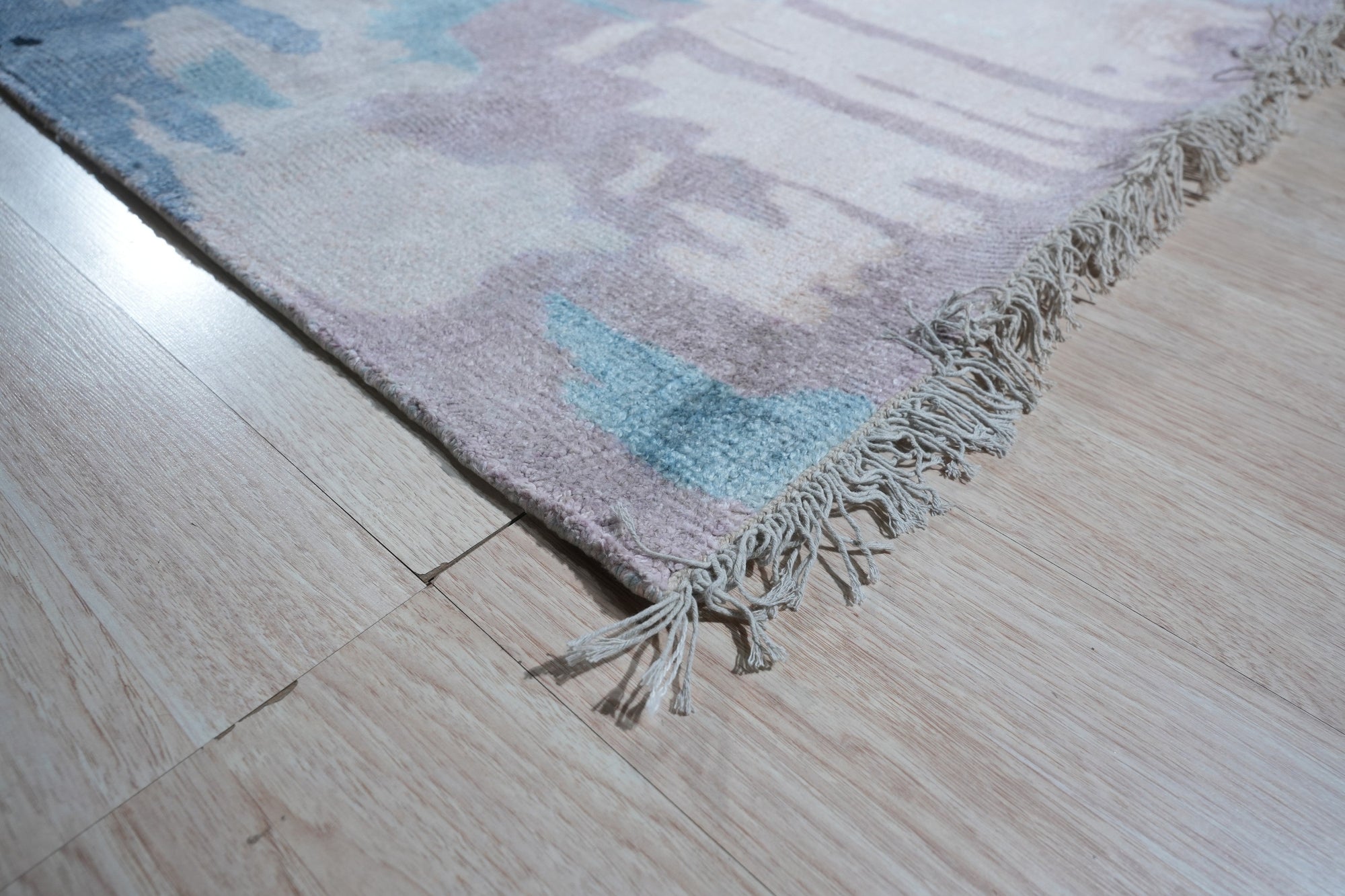 Iris Bianca Multicolor Hand Knotted Bamboo Silk Rug, a vibrant splash of color unfolds across a lustrous bamboo silk rug, its hand-knotted construction evident in the intricate design. Seen in a styled interior setting.