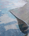 Iris Bianca Multicolor Hand Knotted Bamboo Silk Rug, shimmering with blended hues, sprawls across a light hardwood floor, its intricate design suggesting a blossoming iris rendered in luxurious, silky texture.