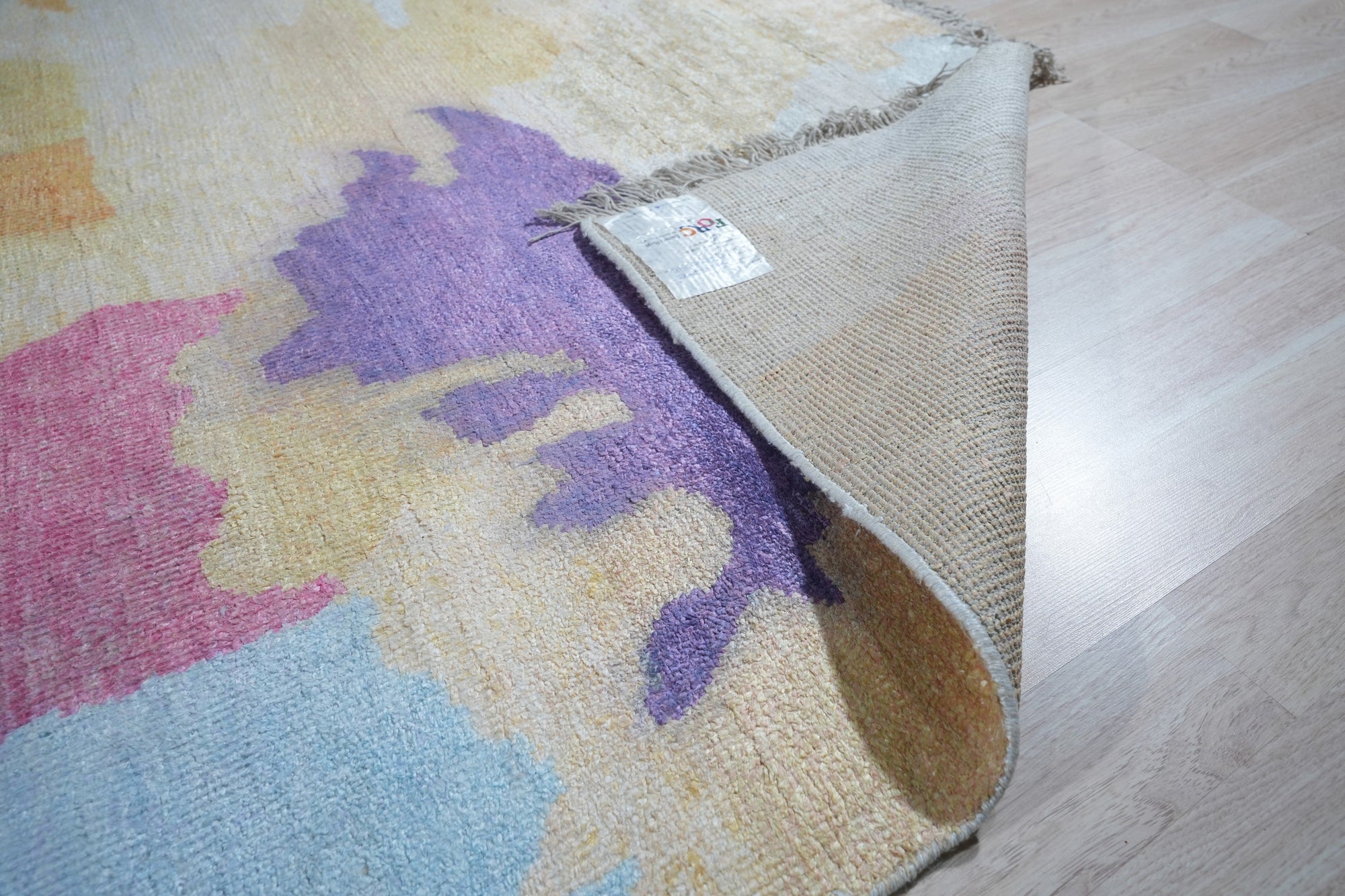 Fiona Trara Multicolor Handmade Bamboo Silk Rug, vibrant blend of hues swirling across a luxuriously soft texture, handwoven bamboo silk catching the light in a modern interior setting.