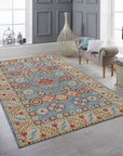 Charming Refined Blue Hand Knotted Wool Rug, features a classic geometric design in shades of blue and ivory, resting on a dark hardwood floor. Warm, inviting light highlights the rug's texture and intricate knotting.