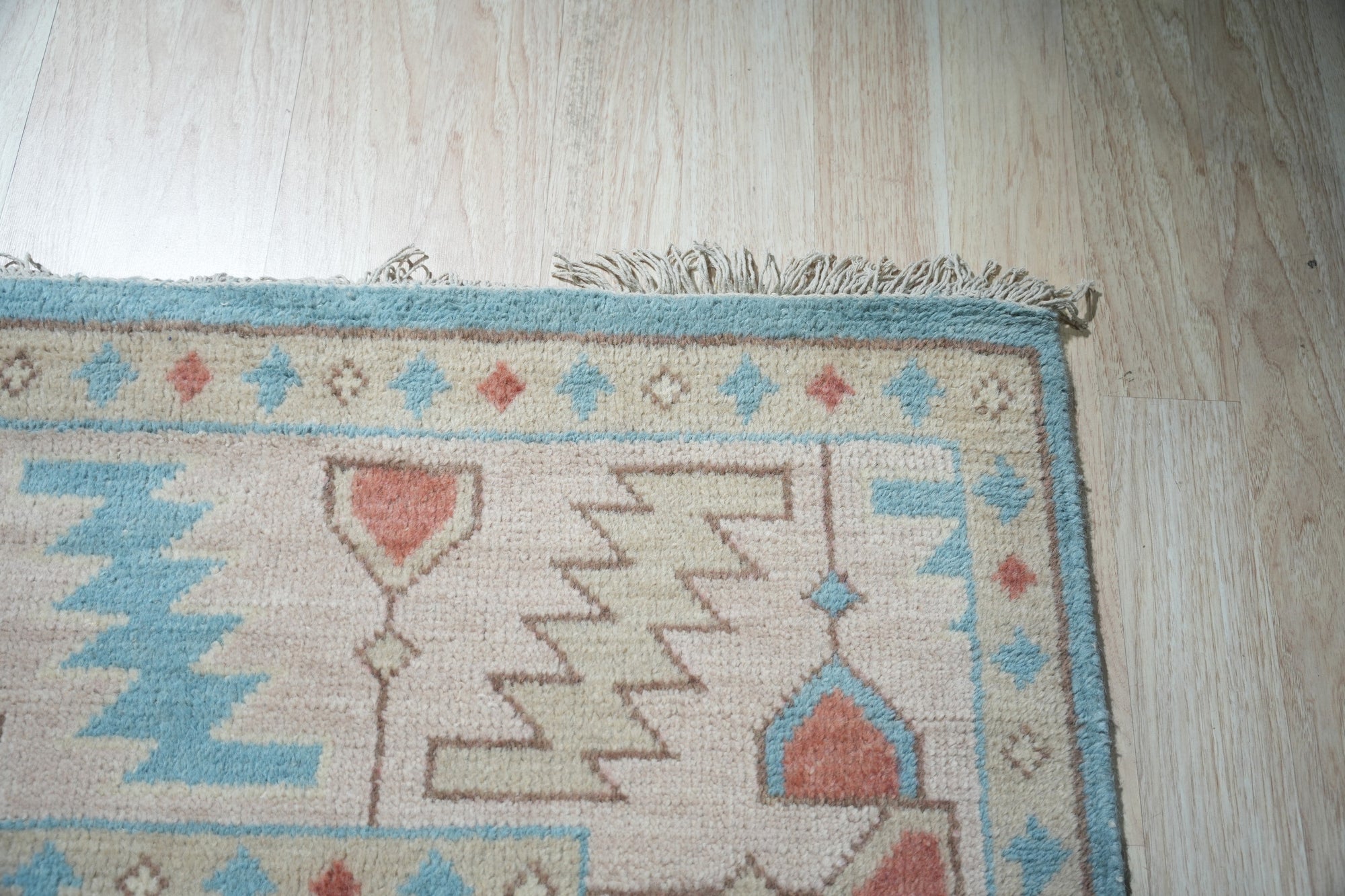 Yara Willow Light Blue Hand Knotted Wool Rug, its tranquil light blue hues and hand-knotted wool texture softening a modern living space, anchored by a sleek black coffee table and bathed in natural light.