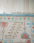 Yara Willow Light Blue Hand Knotted Wool Rug, its tranquil light blue hues and hand-knotted wool texture softening a modern living space, anchored by a sleek black coffee table and bathed in natural light.
