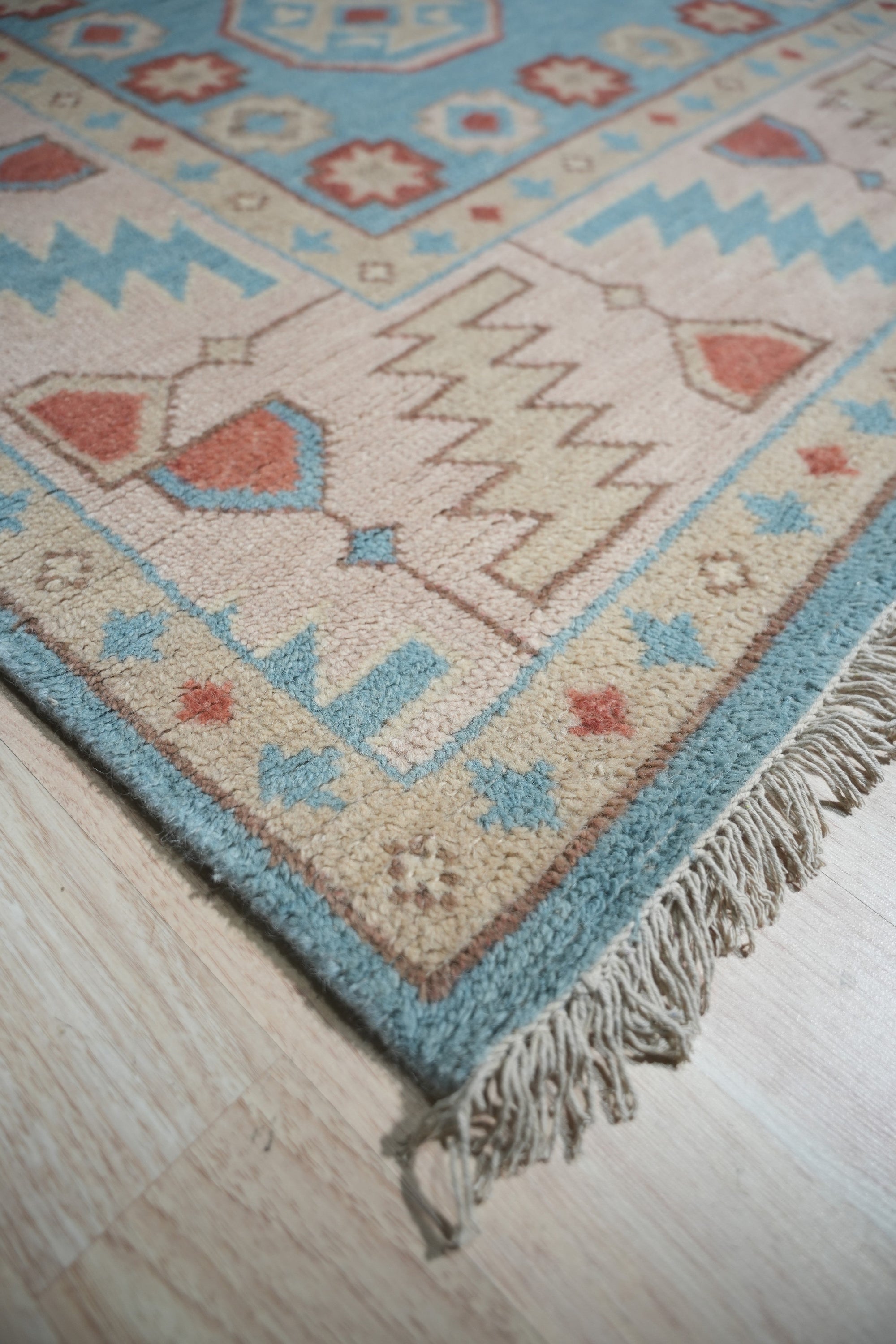 Yara Willow Light Blue Hand Knotted Wool Rug, displayed in a bright, contemporary living space. Light blue tones and subtle willow pattern enhance a cream sofa and warm wood flooring.