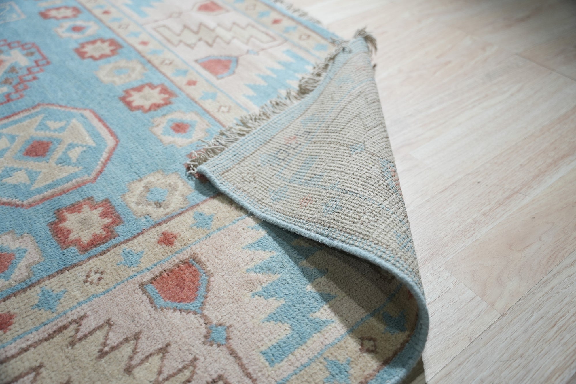 Yara Willow Light Blue Hand Knotted Wool Rug, soft light blue hues and intricate hand-knotted wool construction, laying elegantly in a bright, modern living space.