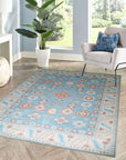 Yara Willow Light Blue Hand Knotted Wool Rug graces a warmly lit living room, its delicate willow pattern unfolding across the soft, light blue wool fibers, anchoring a seating area with understated elegance.