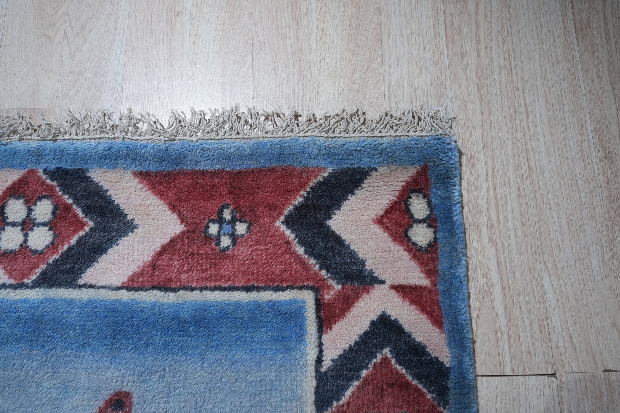Willow Talia Blue Hand Knotted Wool Rug, a cool-toned blue wool rug with a subtly textured, distressed design, complementing a modern living room setting with light wood floors and neutral furniture.