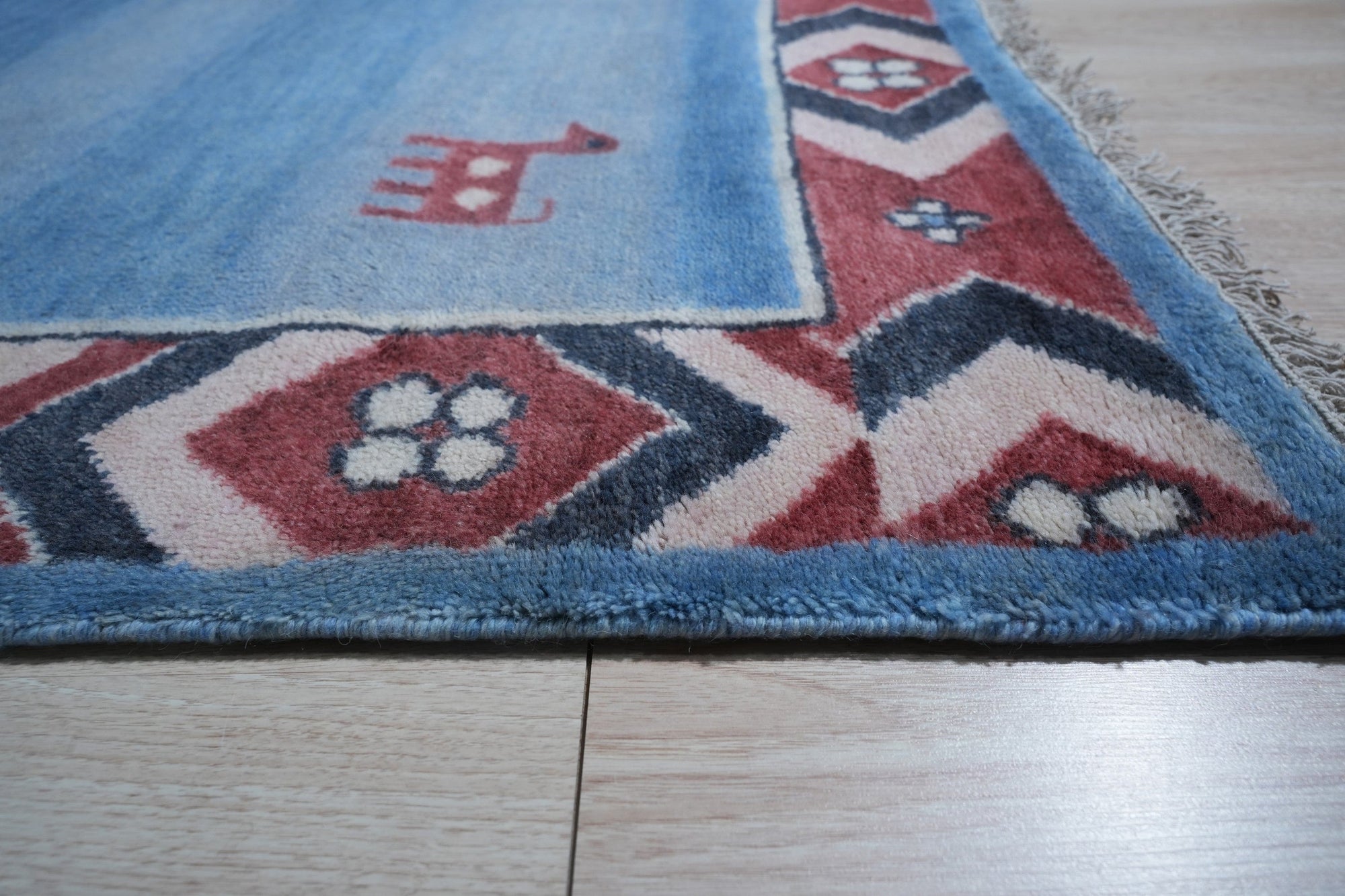 Willow Talia Blue Hand Knotted Wool Rug, blending cool blues in an intricate, hand-knotted wool design, enhancing a warmly lit room.