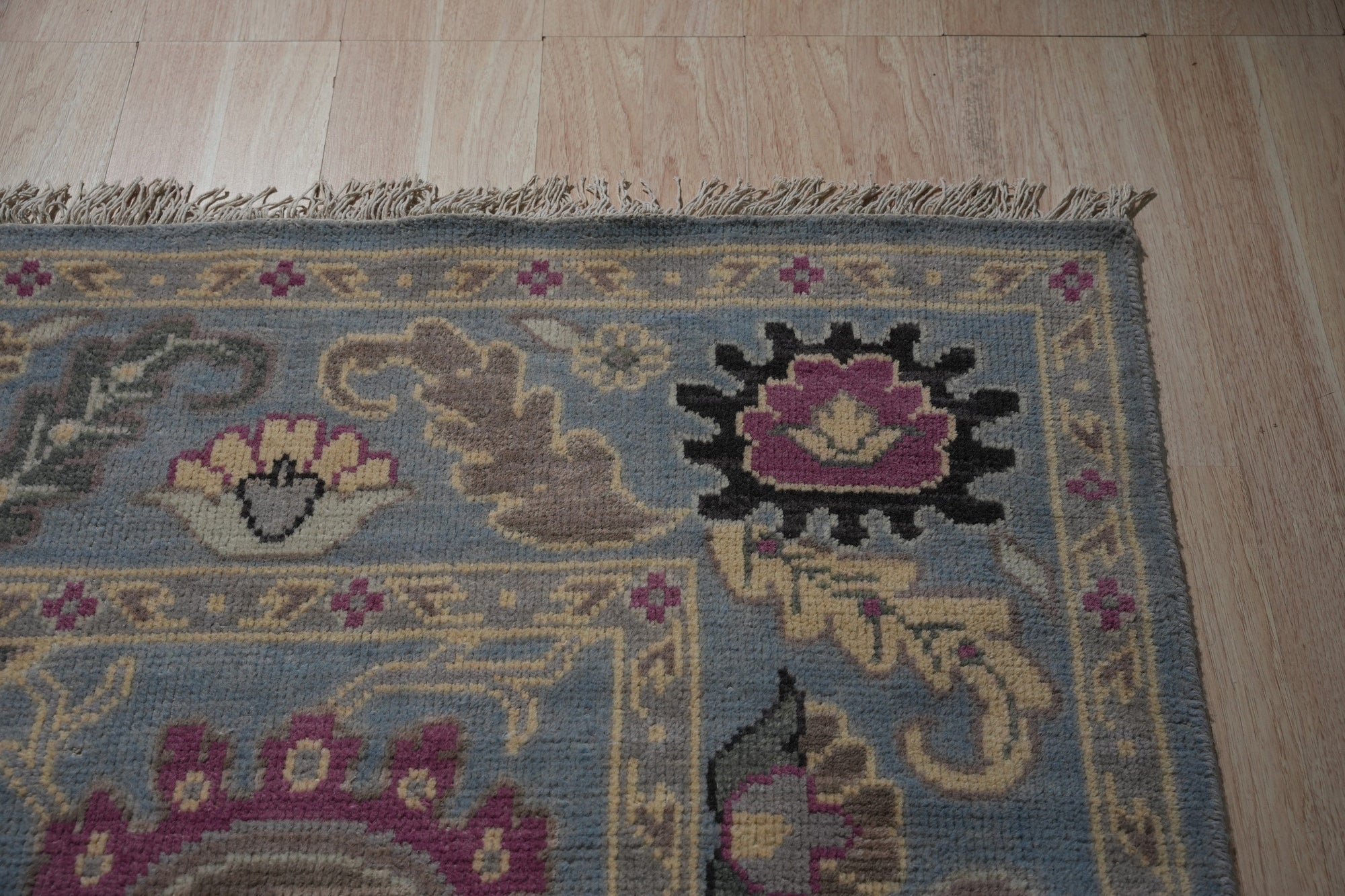 Tessa Laine Blue Hand Knotted Wool Rug, showcasing intricate patterns and luxurious texture, seen in a styled interior setting.