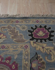 Tessa Laine Blue Hand Knotted Wool Rug, showcasing intricate patterns and luxurious texture, seen in a styled interior setting.