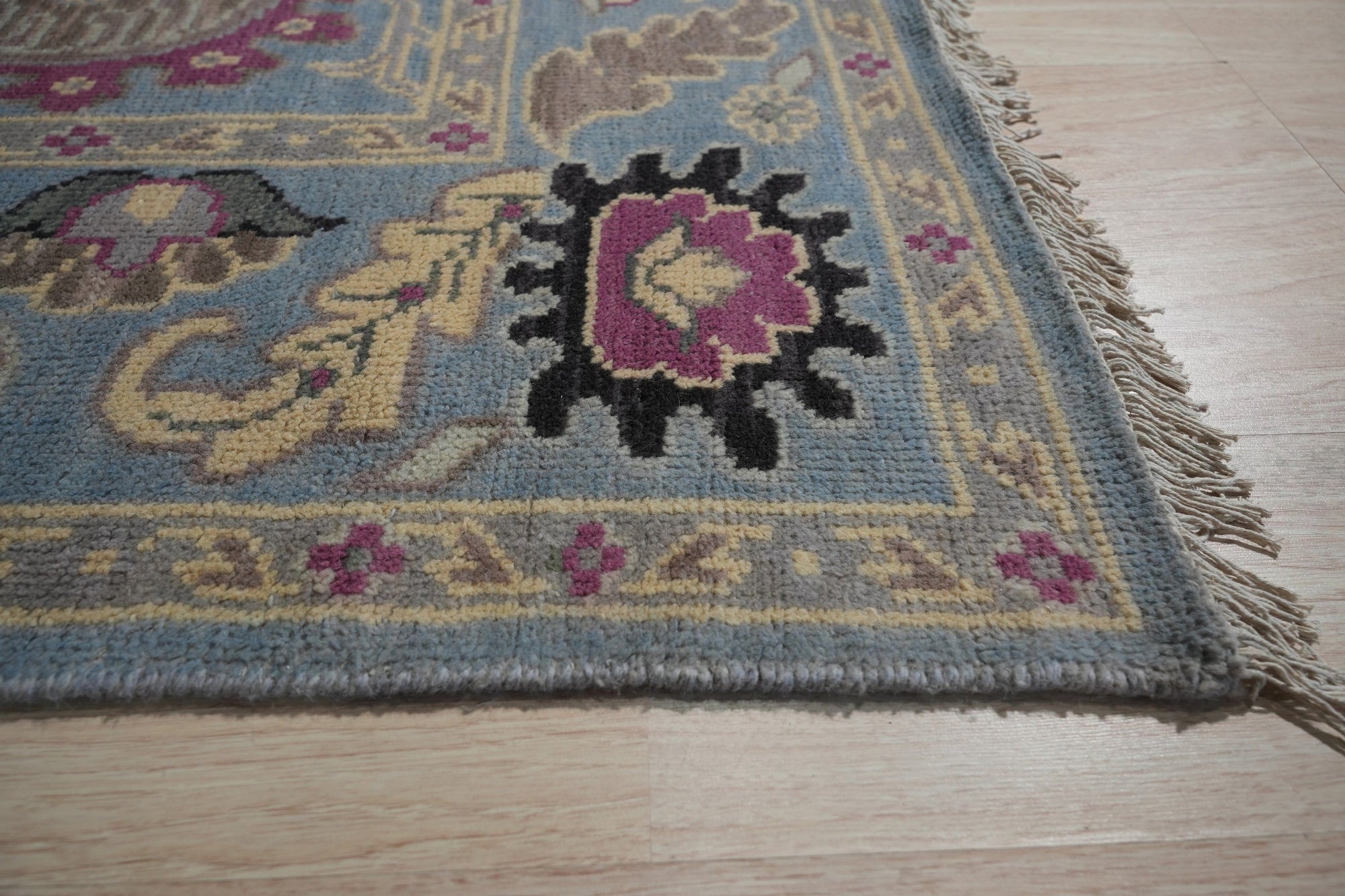 Tessa Laine Blue Hand Knotted Wool Rug, a textured expanse of interwoven wool, displaying intricate knotwork in cool blue tones, softly illuminated in a warm, inviting room setting.