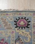 Tessa Laine Blue Hand Knotted Wool Rug, showcasing a modern geometric pattern with varying shades of blue, cream, and gray, laid on a light hardwood floor.