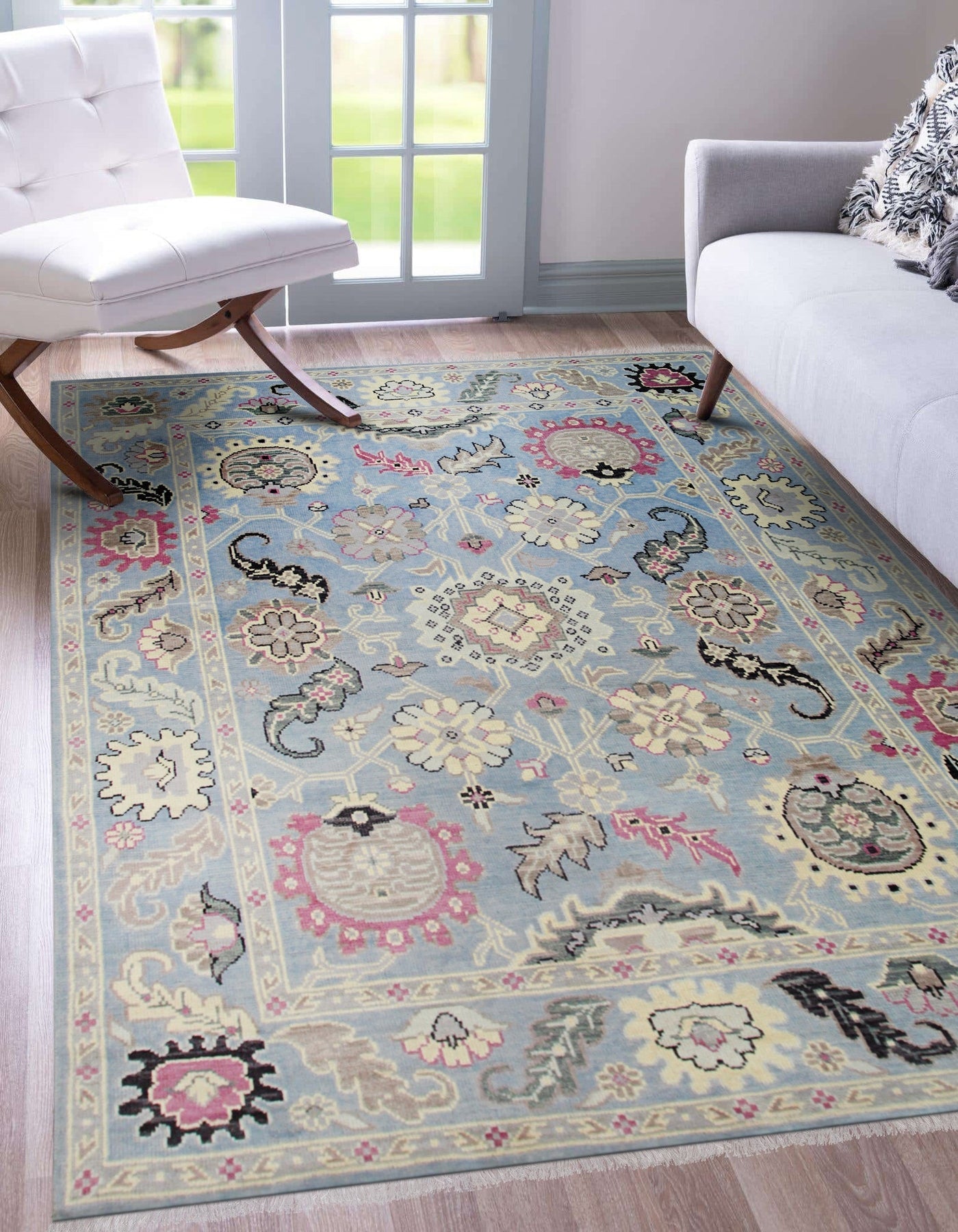 Willow Radiant Light Blue Nan Rug features a subtle, swirling pattern in light blue and cream tones, adding a touch of elegance to a modern living room setting with neutral-colored furniture.