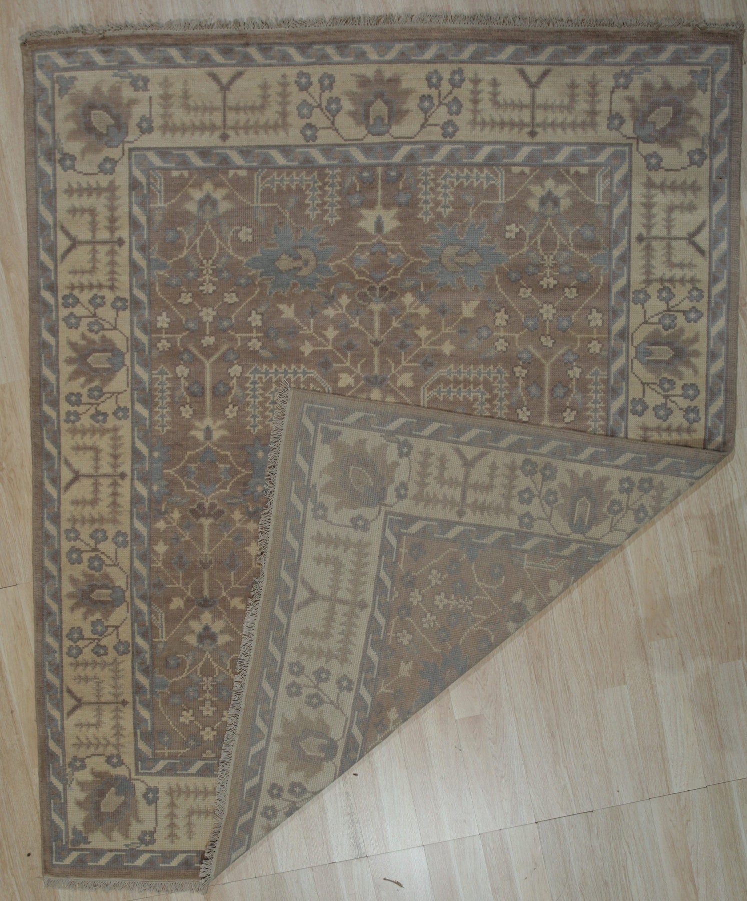 Lydia Sophisticated Brown Hand Knotted Wool Rug, a detailed view showcasing the rug's intricate knotting and warm brown tones, possibly in a styled living room setting.