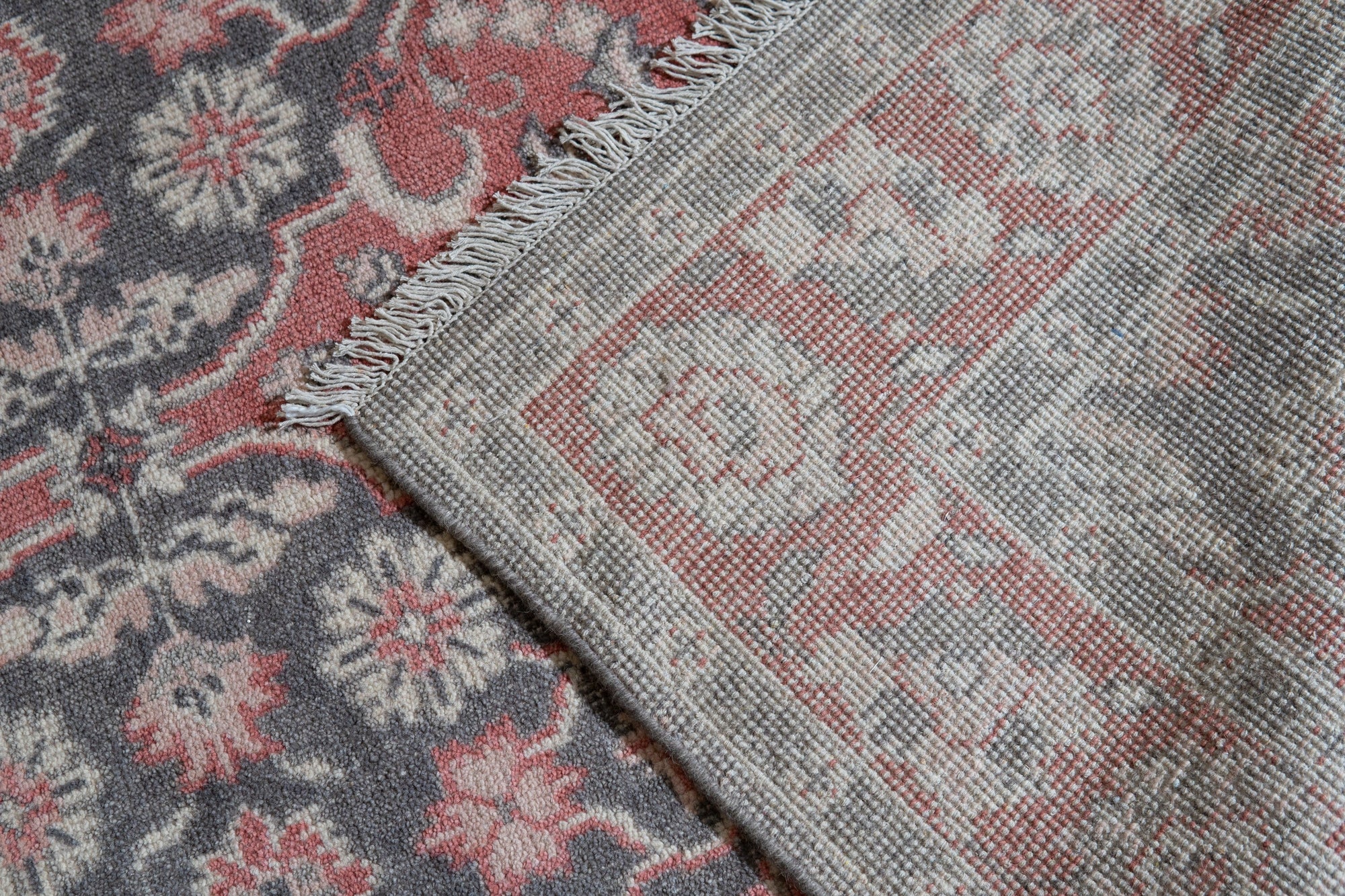 Majestic Classic Rust Hand Knotted Wool Rug, displaying intricate patterns in warm rust tones, lies elegantly in a well-lit room, highlighting the rug's hand-knotted construction and classic design.