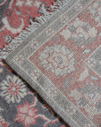 Majestic Classic Rust Hand Knotted Wool Rug, displaying intricate patterns in warm rust tones, lies elegantly in a well-lit room, highlighting the rug's hand-knotted construction and classic design.