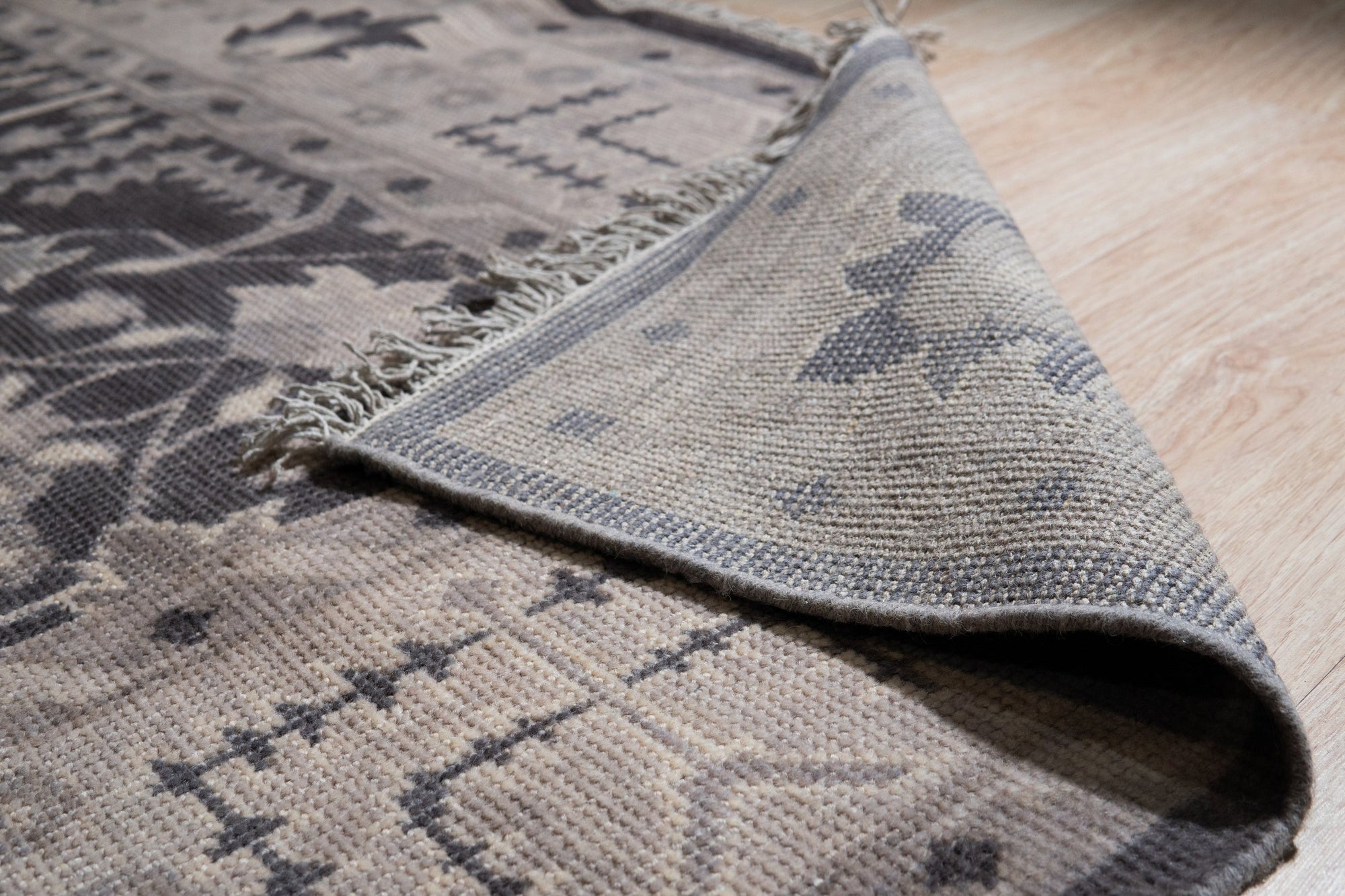 Cozy Oushak Charcoal Hand Knotted Wool Rug, a charcoal wool rug with a classic Oushak design, seen in a bright, airy living space with modern furniture.
