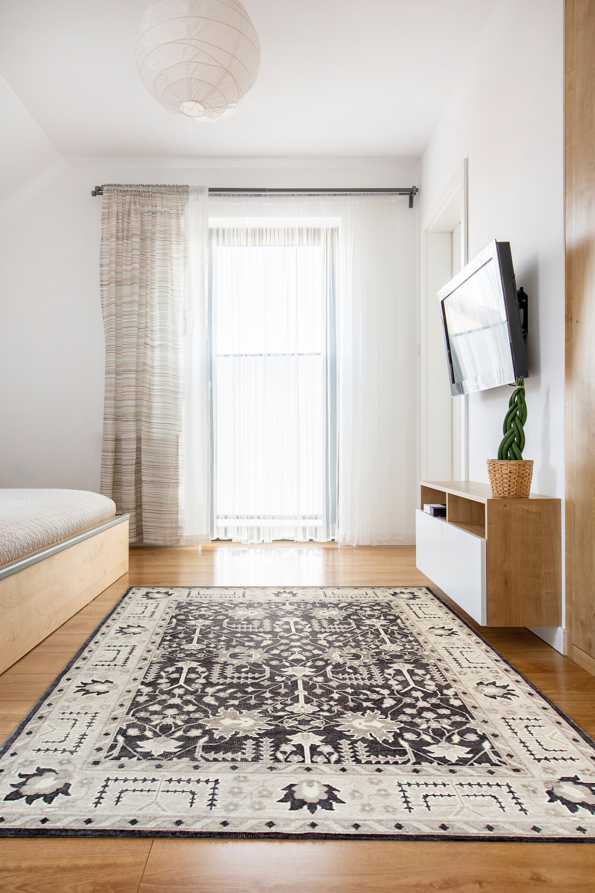 Cozy Oushak Charcoal Hand Knotted Wool Rug, a charcoal wool rug with a traditional Oushak design, seen in a brightly lit room setting, highlighting its intricate details.