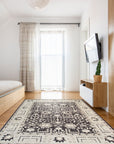 Cozy Oushak Charcoal Hand Knotted Wool Rug, a charcoal wool rug with a traditional Oushak design, seen in a brightly lit room setting, highlighting its intricate details.